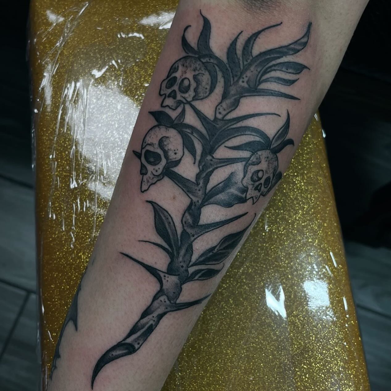 Black-and-grey botanical branch with small animal skulls
