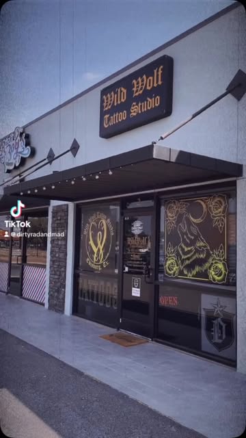 Public reel frame showing the signed Wild Wolf Tattoo Studio storefront
